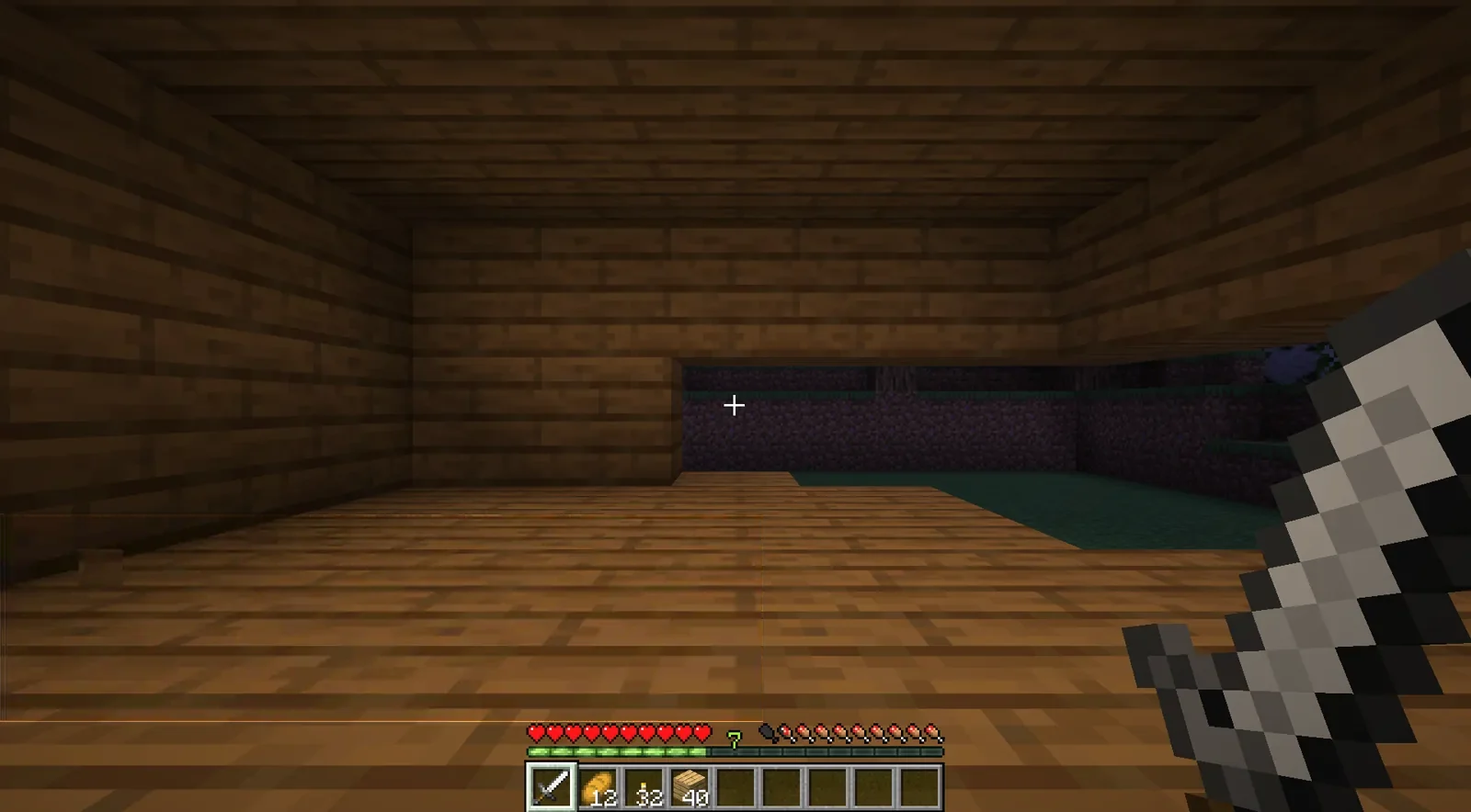 Inside a wooden hut at night, the lower row of the wall chewed away